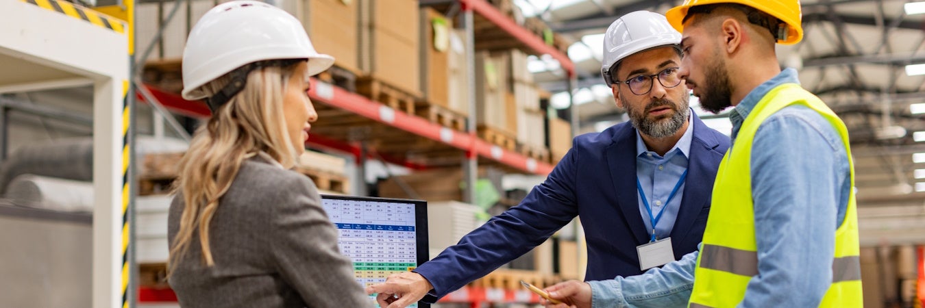 Logistics manager meeting with employees to discuss a spreadsheet